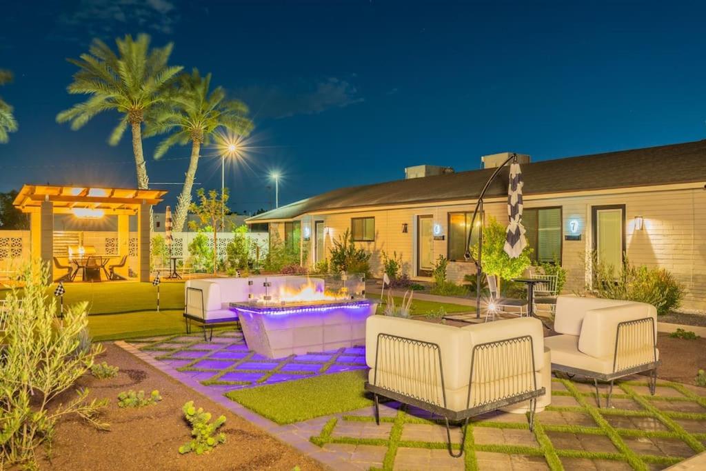 a backyard with white chairs and a fire pit at ASH and KO in Phoenix