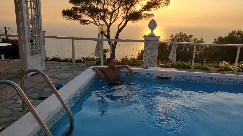 a man is sitting in a swimming pool at bb la guardiia in Anacapri