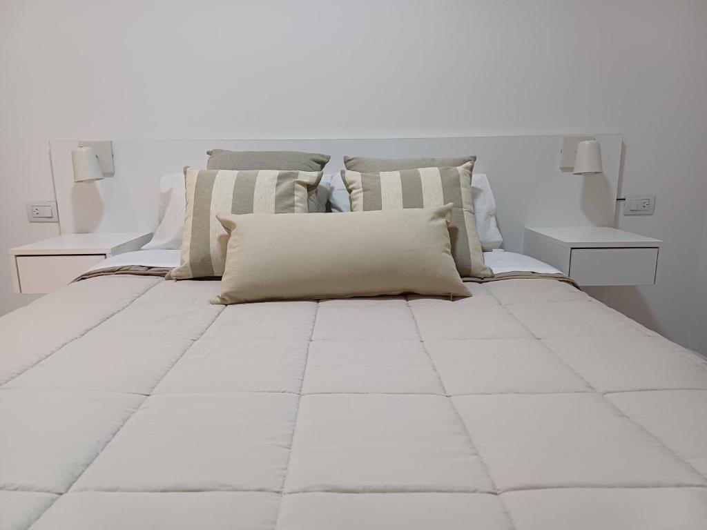 1 dormitorio blanco con 1 cama blanca grande con almohadas en Departamento de un dormitorio - PB en Santa Fe