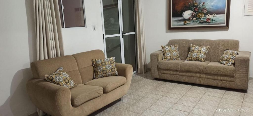 ein Wohnzimmer mit 2 Stühlen und einem Sofa in der Unterkunft Casa no Centro Bananeiras-PB in Bananeiras
