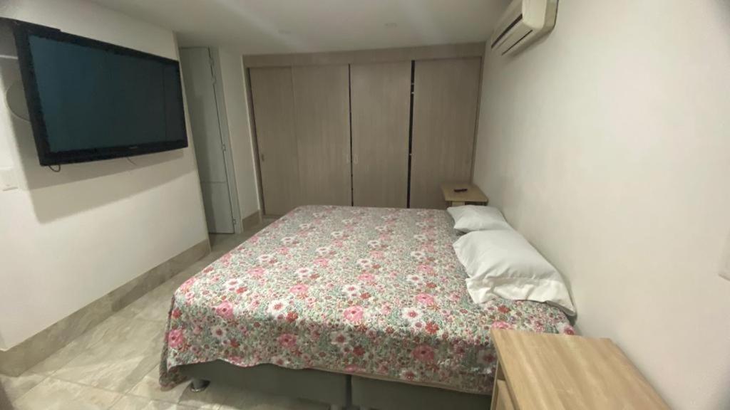 a bedroom with a bed and a flat screen tv at Habitacion Ciudadela Nio 1 in Neiva