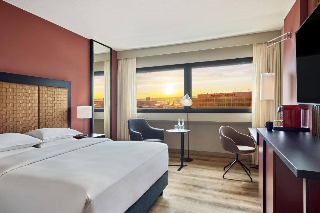 a hotel room with a large bed and a desk at Sheraton Frankfurt Airport Hotel & Conference Center in Frankfurt