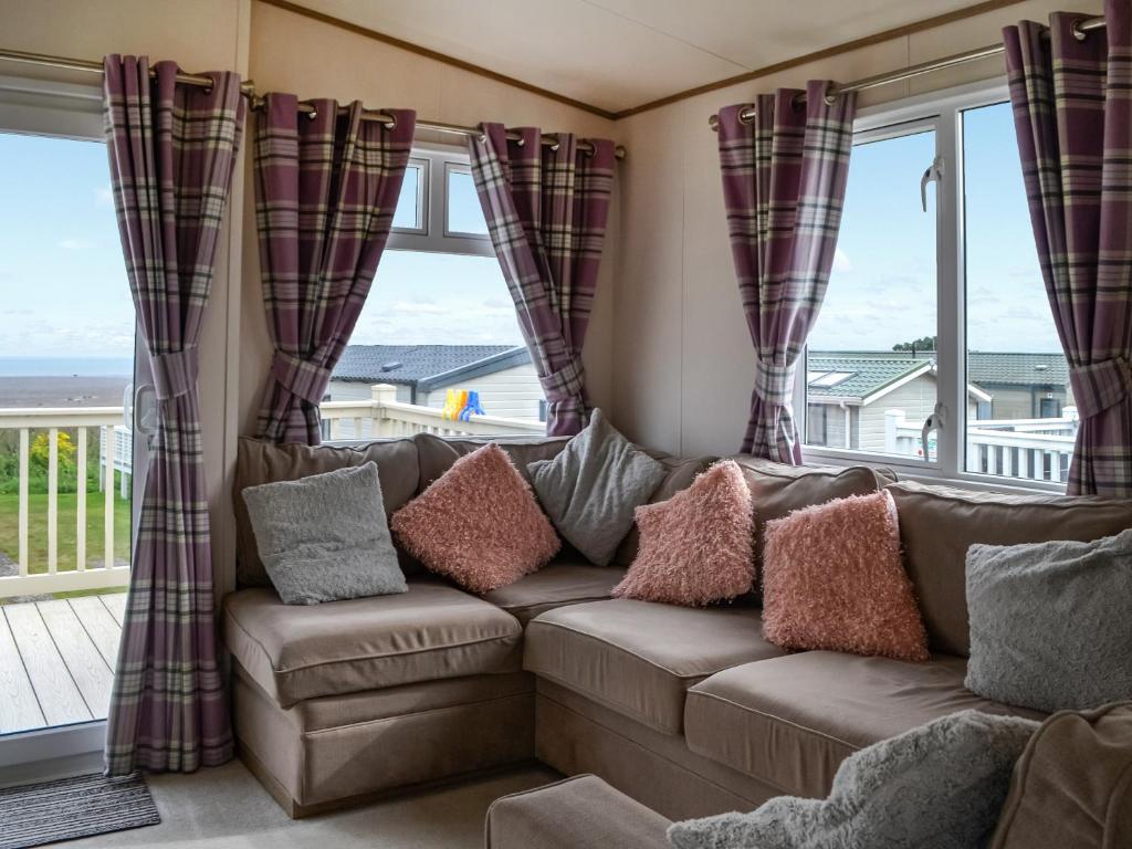 a living room with a couch and windows at Sea View 14 - Uk45161 in Mainsriddle