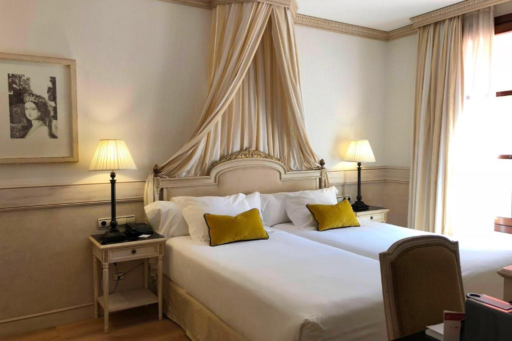 A bed or beds in a room at Eugenia de Montijo, Autograph Collection