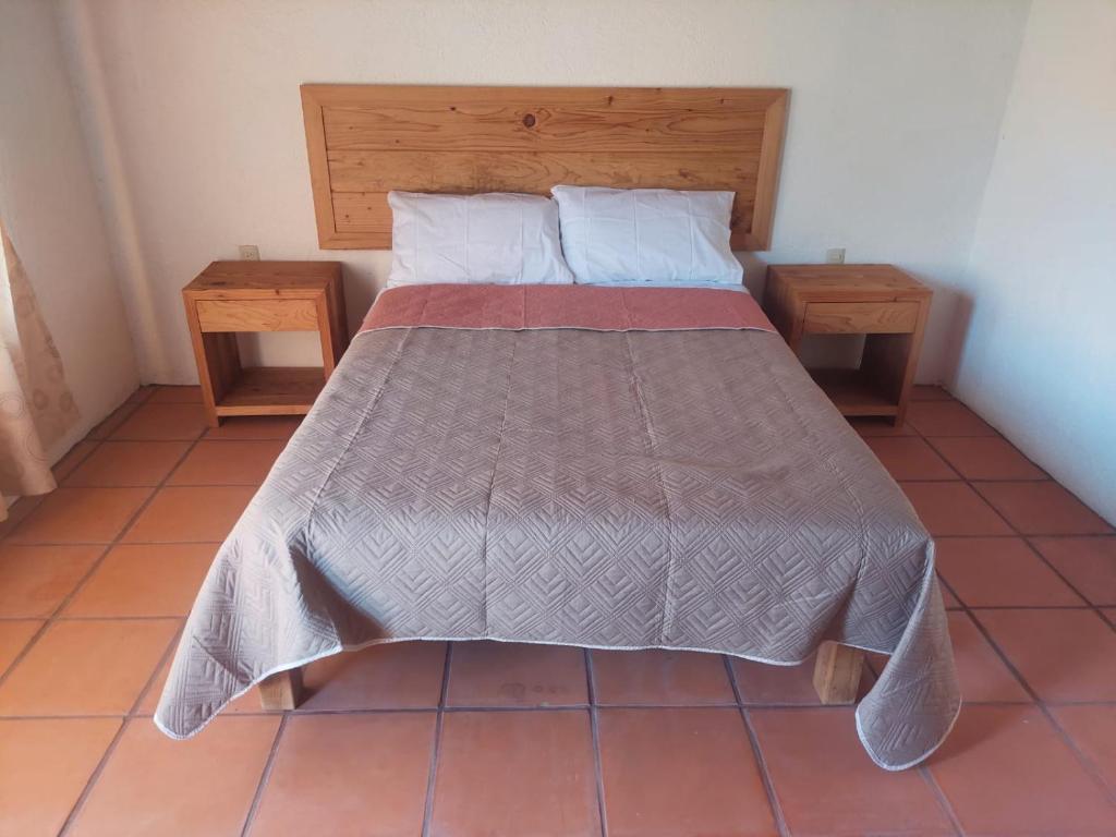 a bed in a room with two nightstandiatesiatesiatesiatesiatesiatesiates at Posada Tia Miny in San Miguel
