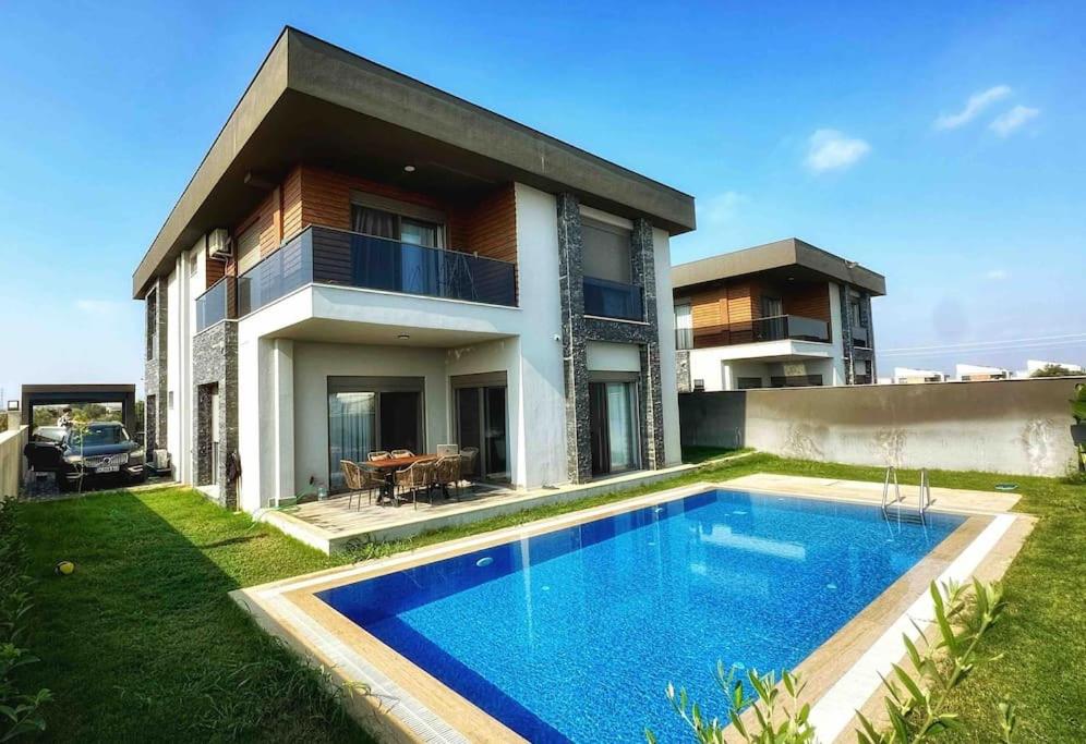 una casa con piscina frente a una casa en Modern Luxury Villa, en Antalya