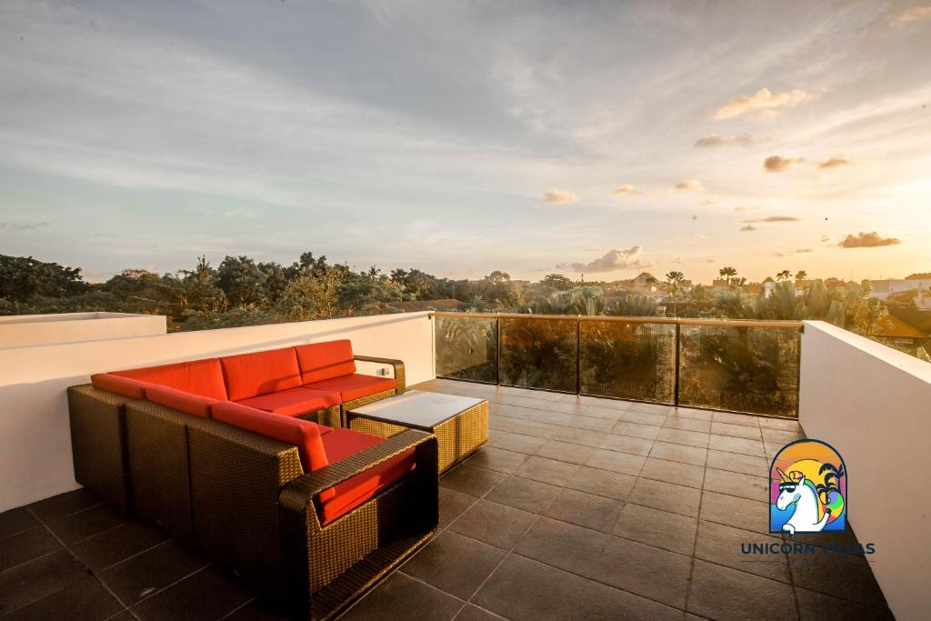 a balcony with a couch and a skateboard at Villa Rufina - by Unicorn Villas Bali in Canggu