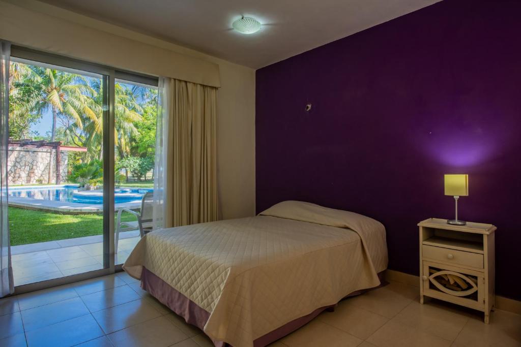 una camera da letto con un letto e una grande finestra di Marysol d11 private beach next to nomads a Isla Mujeres