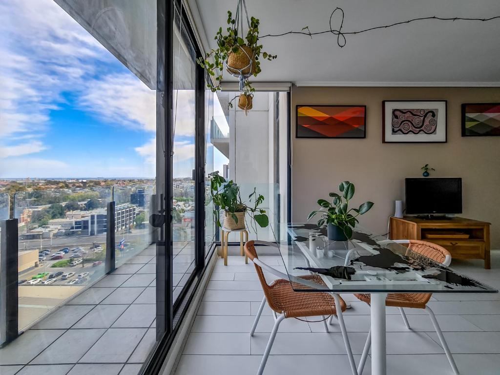 uma sala de jantar com mesa e cadeiras e uma varanda em Ocean view apartment close to CBD with indoor pool. em Melbourne