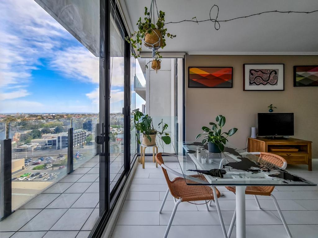 a dining room with a table and chairs and a balcony at Ocean view apartment close to CBD with indoor pool. in Melbourne