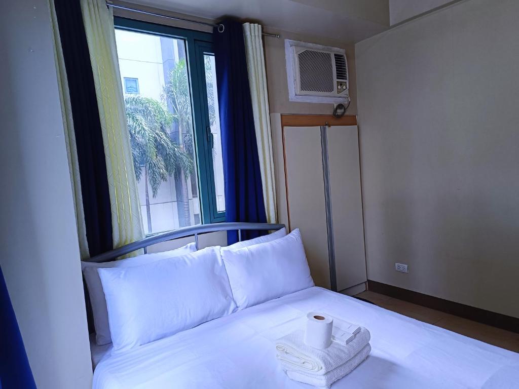 a bed in a room with a window with a towel on it at 1BR at TWO PALMTREE VILLAS Across Manila airport terminal 3 in Manila