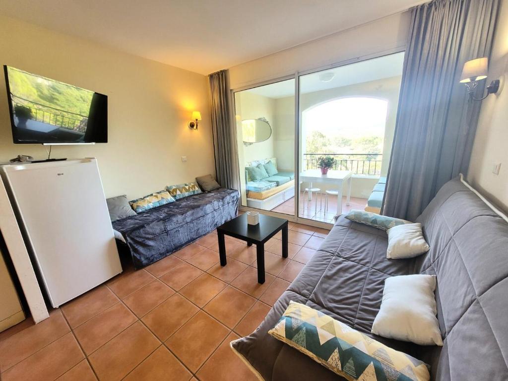 - un salon avec un canapé et une télévision dans l'établissement Village Pont Royal en Provence - maeva Home - Appartement lumineux 2 Pièces 5 P, à Mallemort