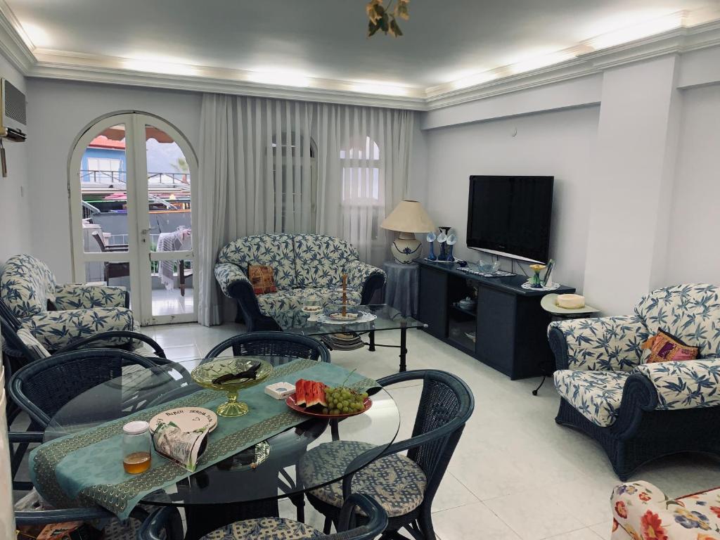 sala de estar con mesa, sillas y TV en Luxury House by the Sea Marmaris, en Marmaris