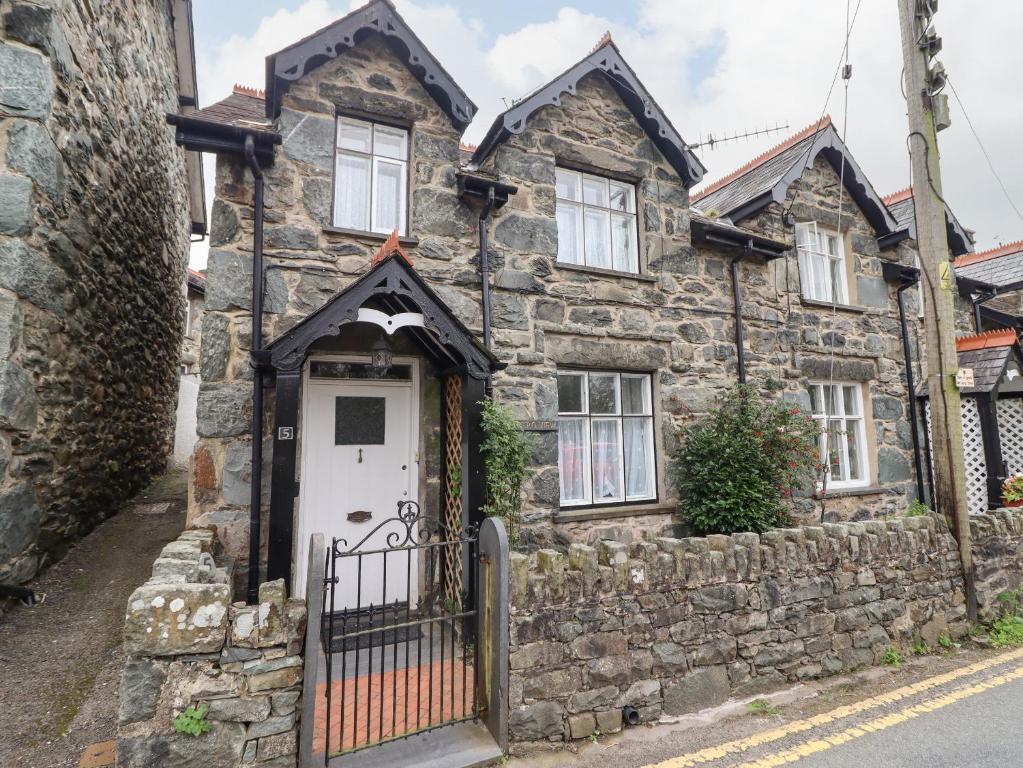 une ancienne maison en pierre avec une porte blanche dans l'établissement Artro View, à Llanbedr