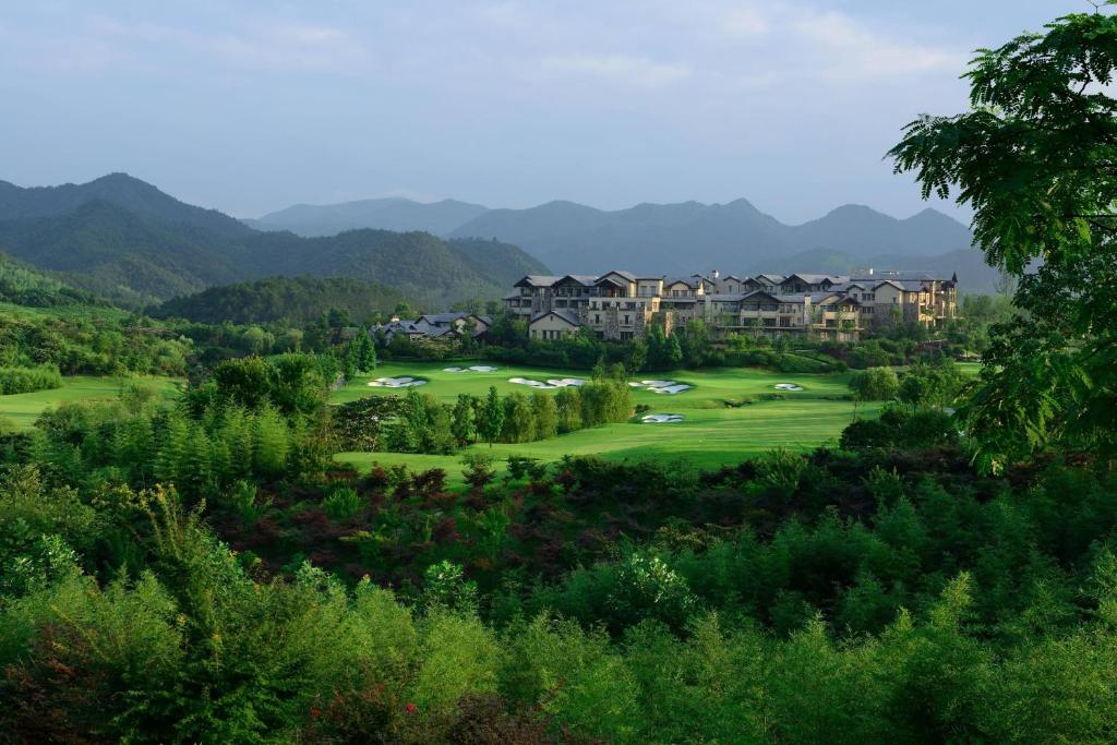 JW Marriott Hotel Zhejiang Anji في انجى: اطلالة ملعب قولف مع جبال في الخلفية