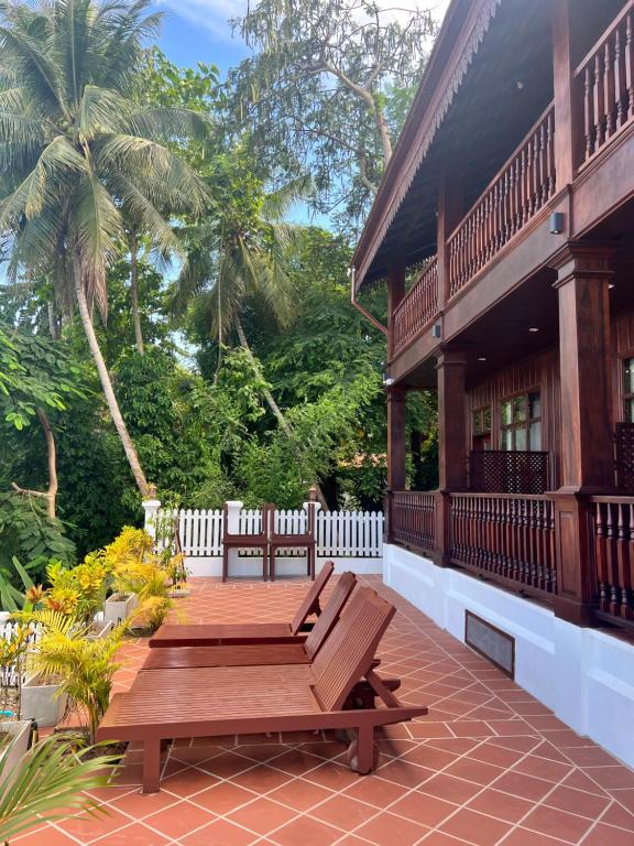 una terraza de madera con un banco en una casa en Namkhan Riverview Aphay en Luang Prabang