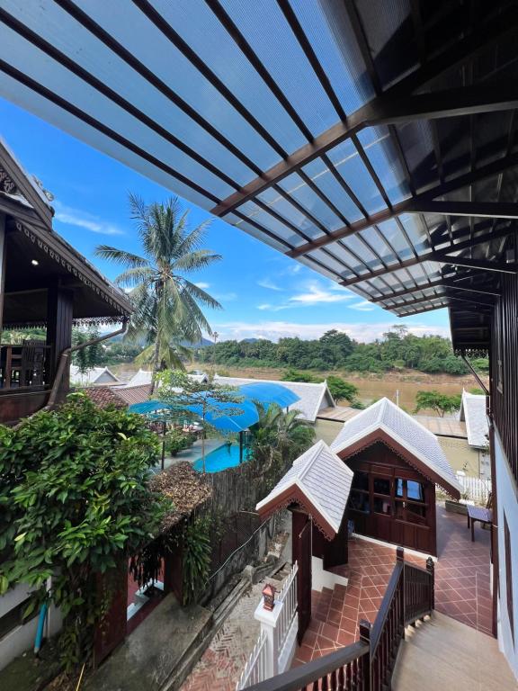 une vue sur la piscine depuis le balcon d'un complexe hôtelier dans l'établissement Namkhan Riverview Aphay, à Luang Prabang