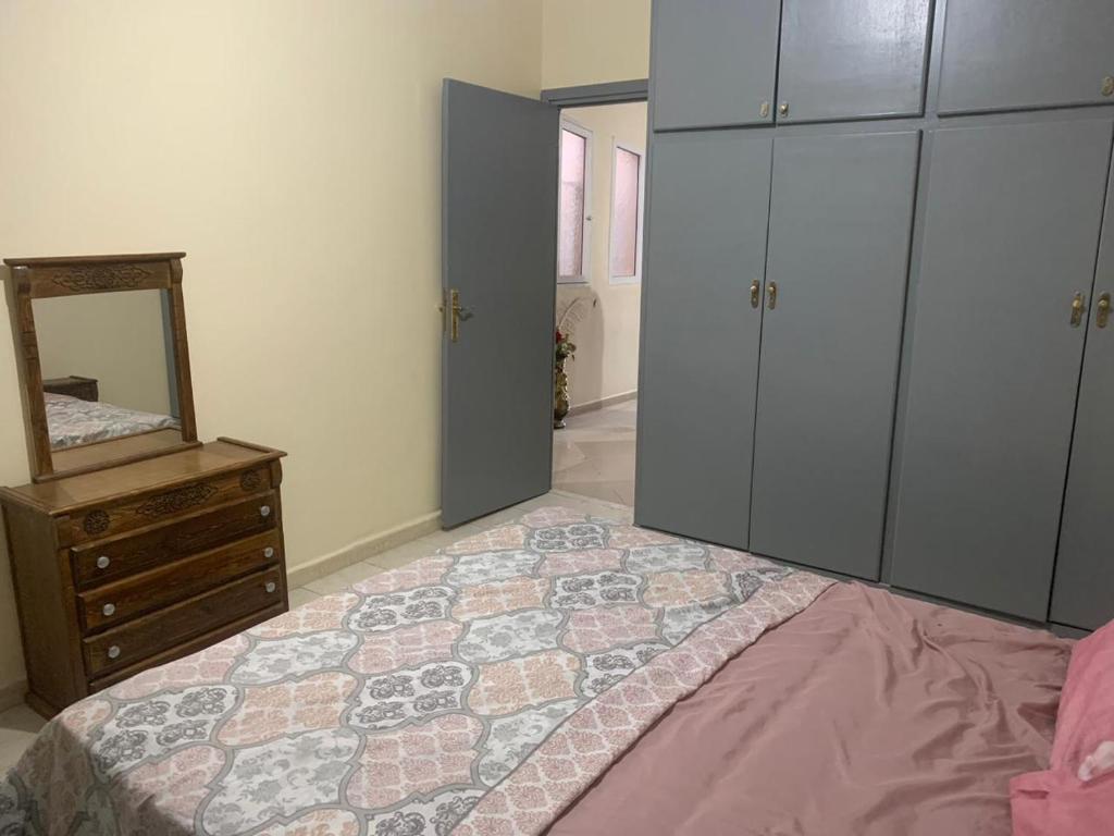a bedroom with a bed and a dresser and a mirror at Apartement Boulevard Mohammed Derfoufi Oujda in Oujda