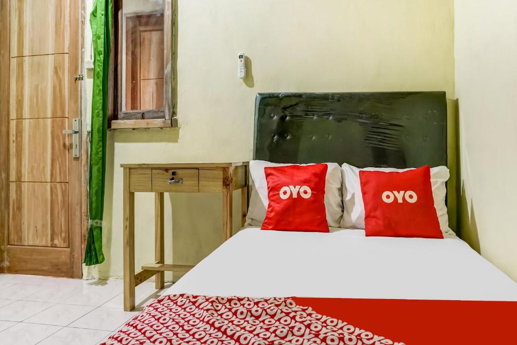 a bedroom with a bed with two red pillows at OYO Life 91335 Micheline Family 2 Syariah in Karawang