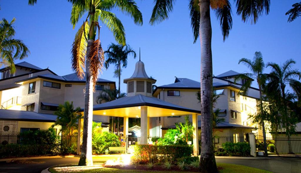 a building with palm trees in front of it at Club Wyndham Cairns in Cairns