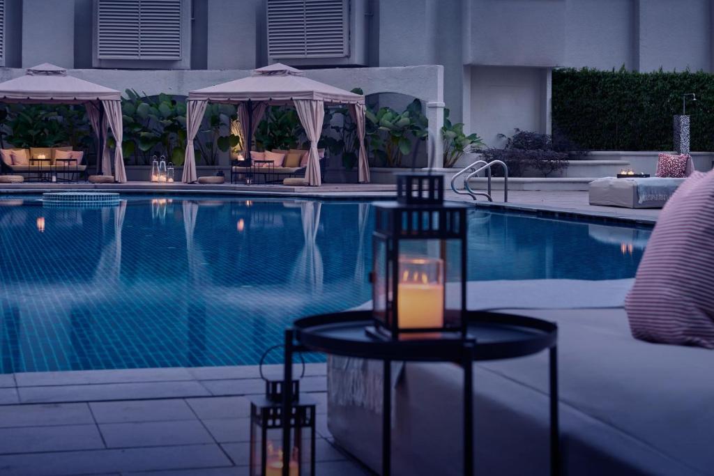 JW Marriott Kuala Lumpur في كوالالمبور: وجود شمعه على طاوله بجانب المسبح