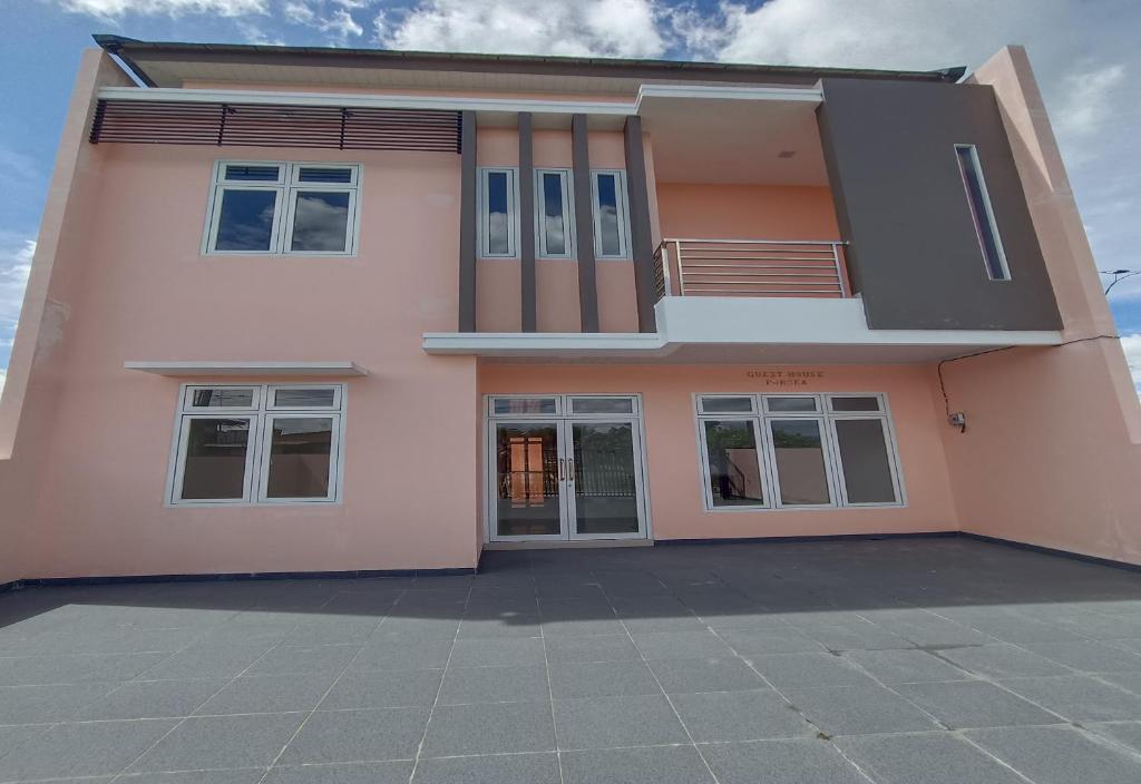 a pink house with a lot of windows at OYO Life 93054 Th Residence 135 Syariah in Medan
