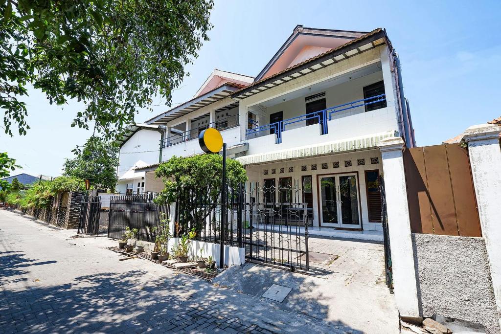 una casa bianca con una recinzione di fronte di OYO Life 1942 Asia Residence Syariah a Semarang