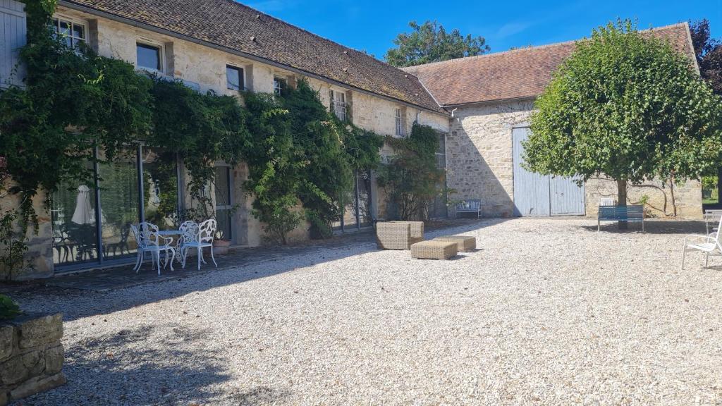 une cour d'un immeuble avec une table et des chaises dans l'établissement Magnifique duplex avec terrasse dans corps de ferme, à Villiers-sous-Grez