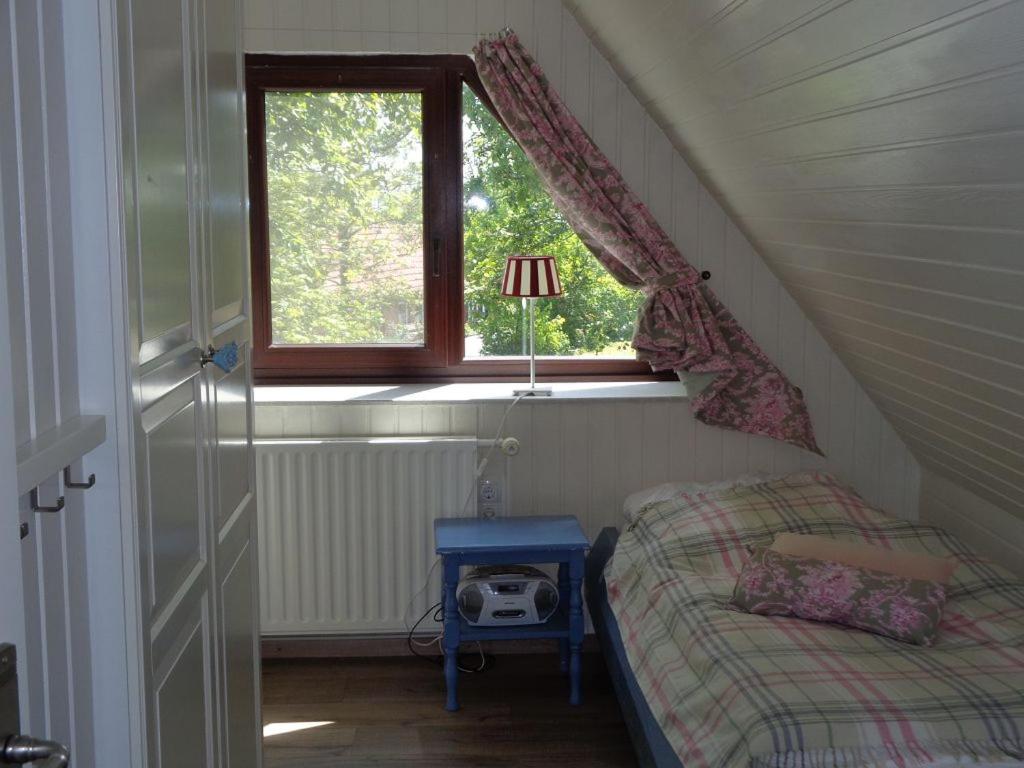 a small bedroom with a bed and a window at Haus Dat lüttje Huus in Krummhörn