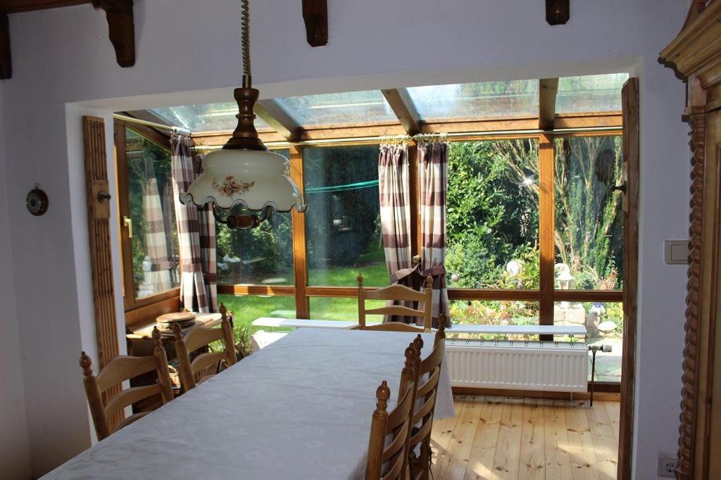 ein Esszimmer mit einem Tisch und einem großen Fenster in der Unterkunft Haus Leevke in Pewsum