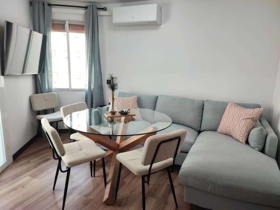 a living room with a glass table and a couch at Cosy flat a few min to Barcelona emblematic sites in Cornellà de Llobregat