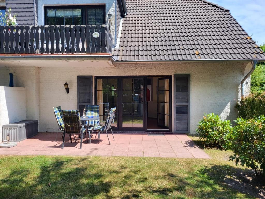 a patio with a table and chairs in front of a house at Wohnung Karina in Krummhörn