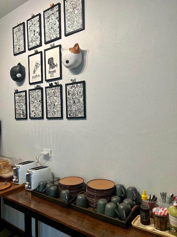 a counter with plates and pictures on a wall at Chern Chiangmai Boutique Hotel in Chiang Mai