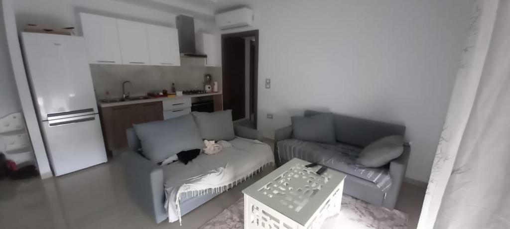 ein Wohnzimmer mit einem Sofa und einem Tisch in der Unterkunft Dar Othman in Akouda