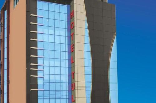 a tall building with a lot of windows on it at Hotel Tulip in Jogīkuti