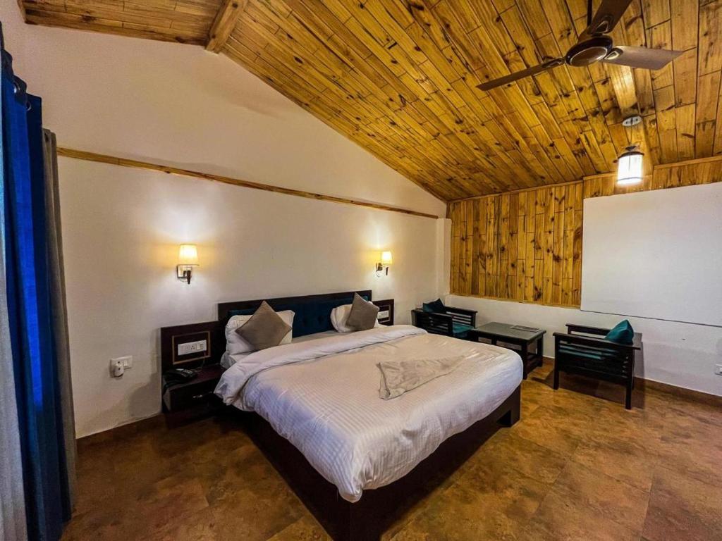 a bedroom with a large bed with a wooden ceiling at Mountain View Resort Nainital in Nainital