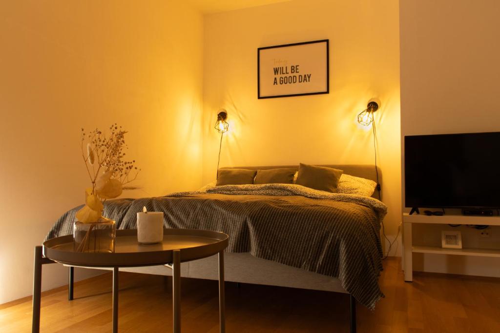 1 dormitorio con cama, mesa y TV en Modern - Calm - Cozy - self CheckIn - stylish new apartment near center - close to U4 en Viena