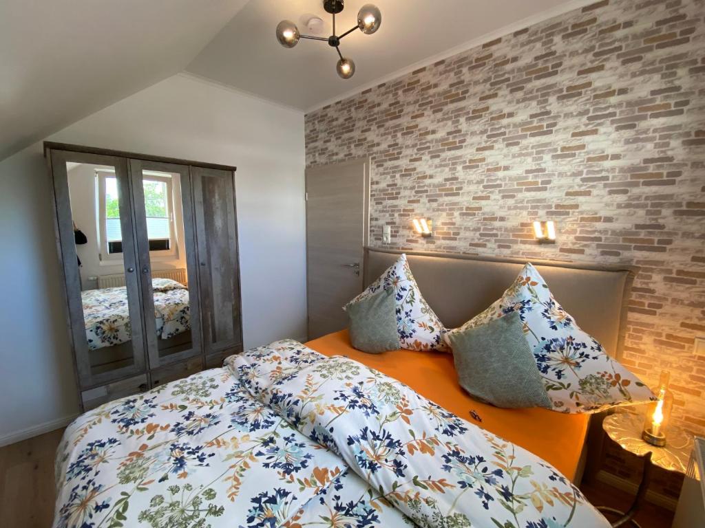 una camera da letto con letto, cuscini e specchio di Arween & Abendrot a Göhren