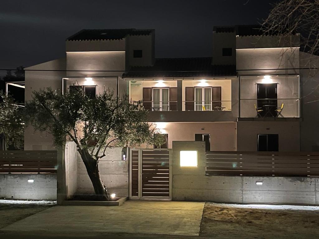 una casa por la noche con un árbol delante de ella en Villa Rodelia en Roda