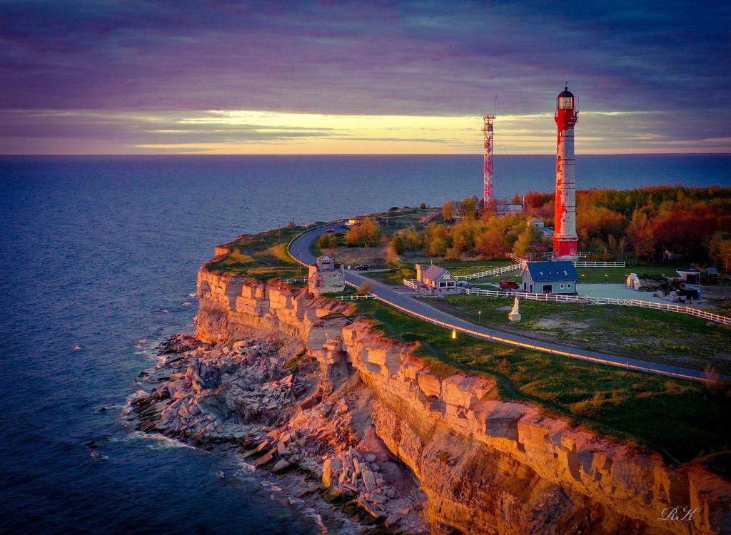 a lighthouse on a cliff next to the ocean at Pakri Parun in Paldiski