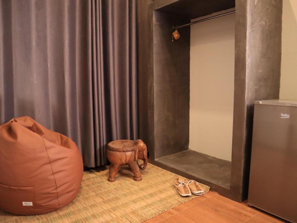 a room with a elephant and a chair and shoes at Chern Chiangmai Boutique Hotel in Chiang Mai