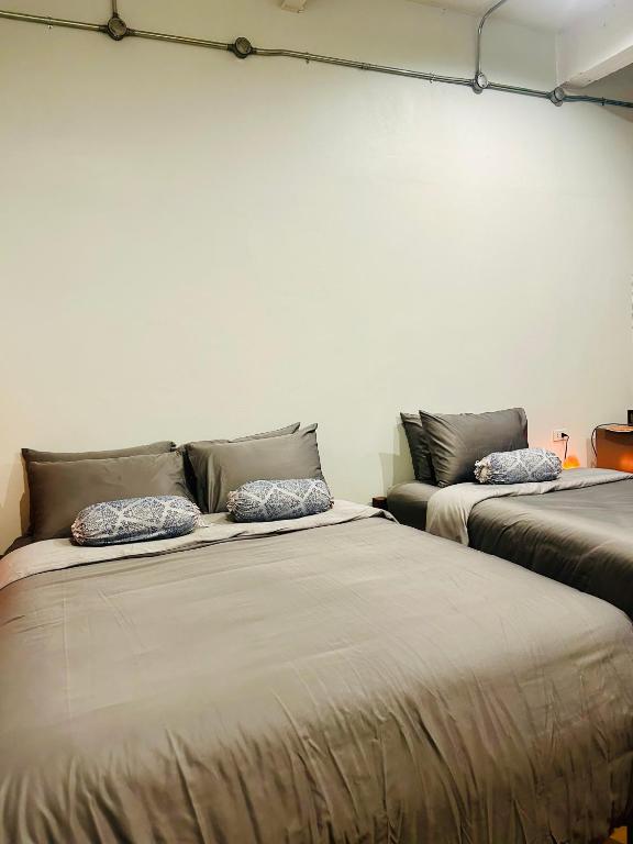 two beds sitting next to each other in a room at Chern Chiangmai Boutique Hotel in Chiang Mai