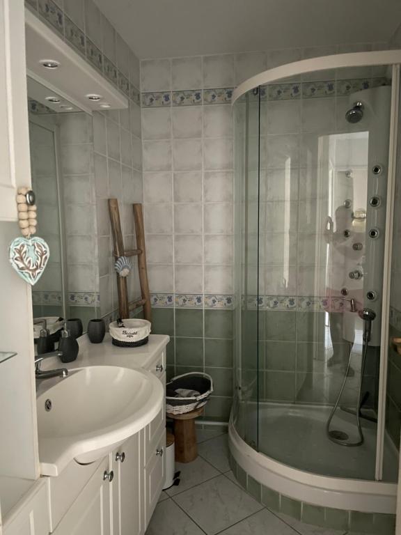 een badkamer met een bad, een wastafel en een douche bij Appartement in La Londe-les-Maures