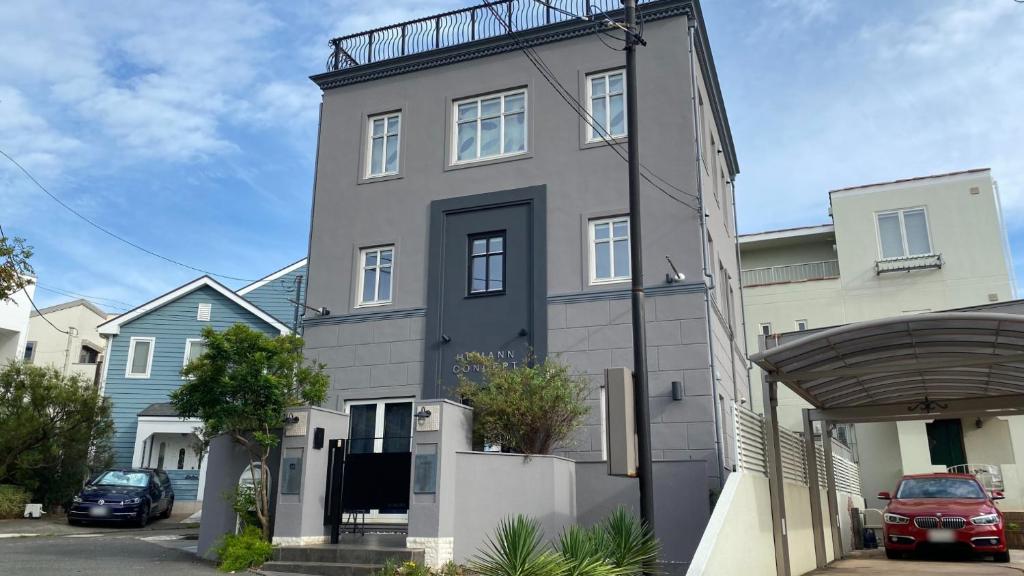 a gray house with a fence on top of it at Tabinoteitaku Kamakura Yuigahama -Homann Concept- in Kamakura