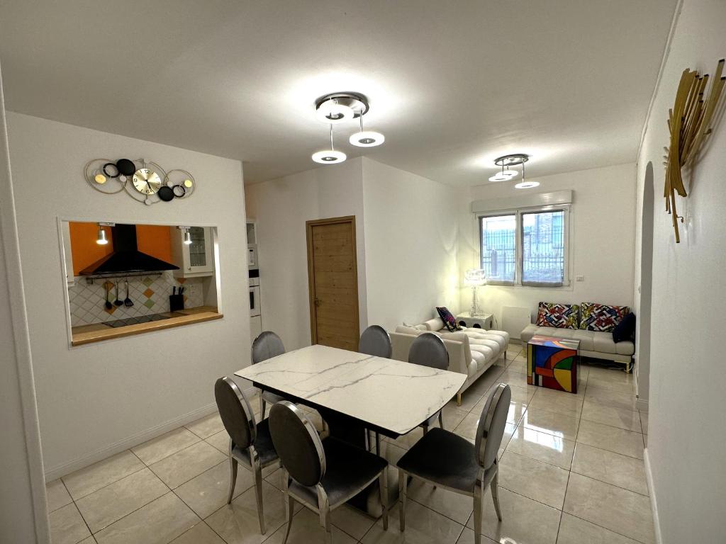 une salle à manger et un salon avec une table et des chaises dans l'établissement ARENA Center Town, à Reims