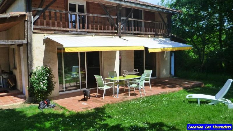 une maison avec un patio avec une table et des chaises dans l'établissement Les Houradets, à Monbardon