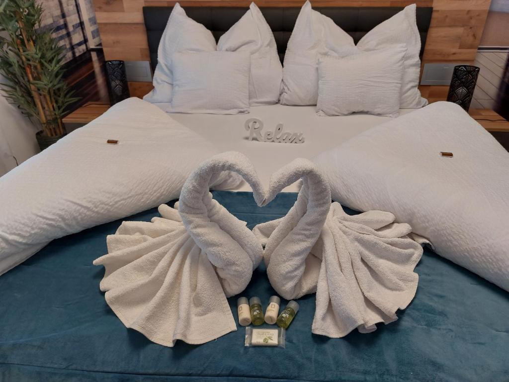 a bed with two towels and two swans at Happiness Apartman in Kecskemét