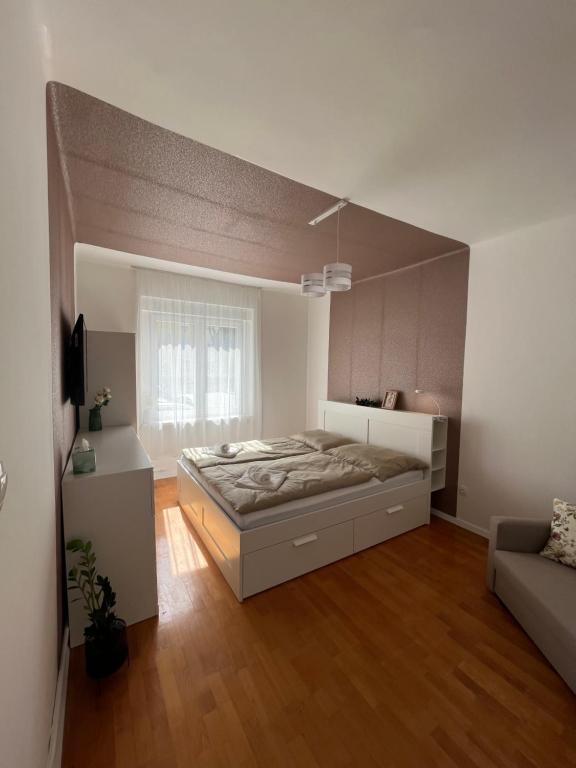 a large bedroom with a bed and a couch at S1 Apartman in Szombathely