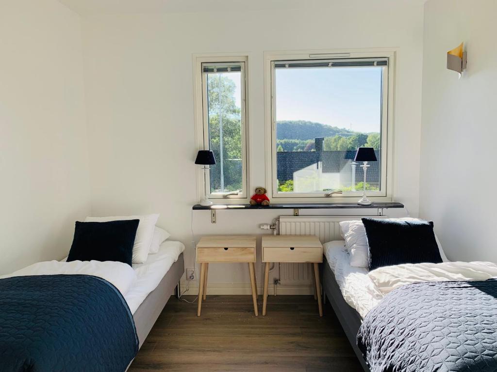 1 dormitorio con 2 camas, escritorio y ventana en Le Coq Heureux en Vånga