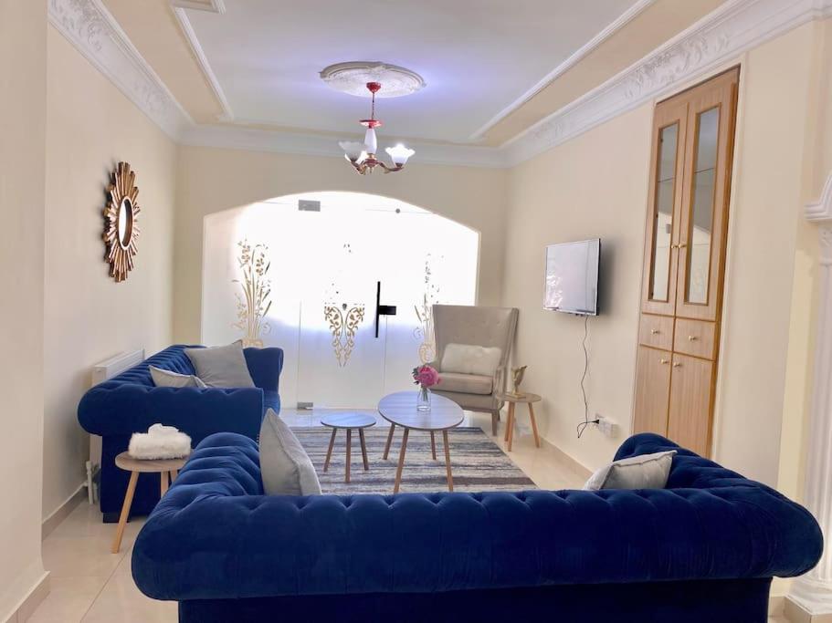 a living room with a blue couch and a table at Great location apartment in Amman
